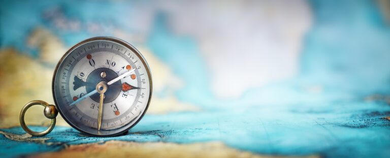 magnetic old compass on world map.travel, geography, navigation, tourism and exploration concept wide background. macro photo. very shallow focus.